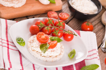 Rice cakes with milk flakes and tomato.
