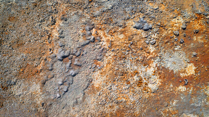 Rough wall texture in abandoned mine with spots of rust and peeling plaster