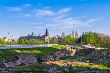 Ruins of the Koenigsberg castle in the historic city center on a sunny spring day. In the background there is the Cathedral on the island of Kant. Russia, Kaliningrad - 452200885