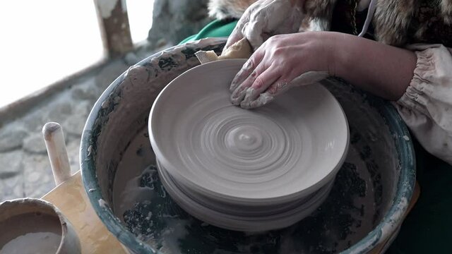 potter's hands at work, creating a bowl of clay