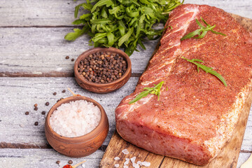 A piece of raw pork loin, marinated fresh meat with spices