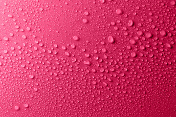 Water drops on smooth surface, red background
