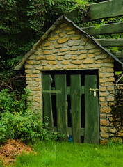 Kamienna komórka z drzwiami z desek . A stone shed with a wooden door. 