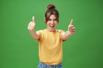 Portrait of cheerful enthusiastic and excited emotive beautiful european woman in yellow t-shirt...