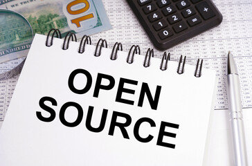 On the table there is money, a calculator and a notebook with the inscription - OPEN SOURCE