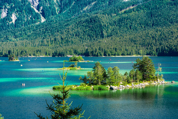 Faboulus landscape of Eibsee Lake with turquoise water in front of Zugspitze summit under sunlight....