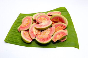 Fresh pink guava on banana leaf on white background.