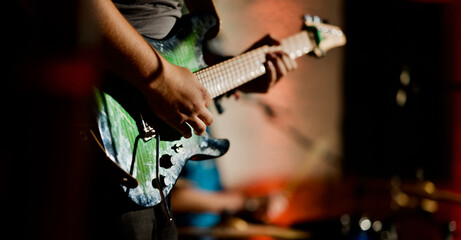 Naklejka premium Rock music background, bass guitar player, closeup photo with selective focus and motion blur effect 