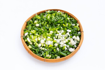 Chopped spring onions in bamboo basket on white background.