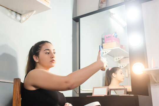Beautiful young girl taking a selfie with her smartphone in her room.