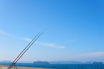 Two fishing rods on the Brixham seaside. Rod rings. Fishing tackle. Fishing spinning reel.
