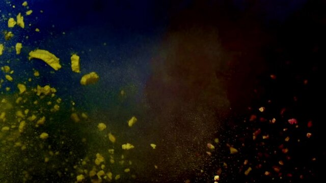 Color burst of blue, red and yellow powder. black background
