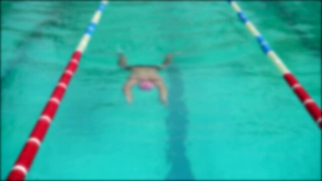 Swimming pool training. Athletes practice swimming technique. Out of focus. Slow motion.