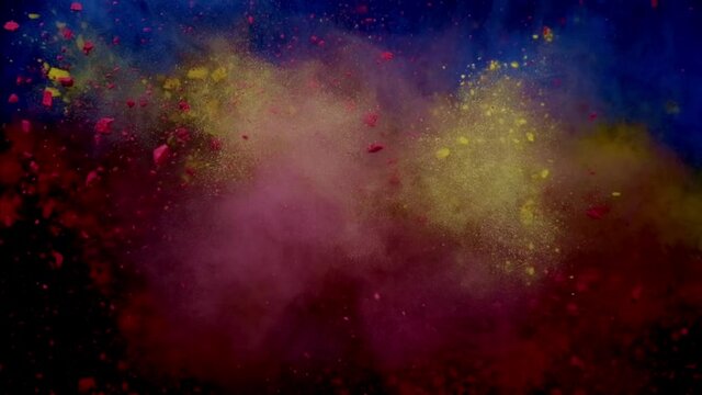 Color burst of blue, red and yellow powder. black background