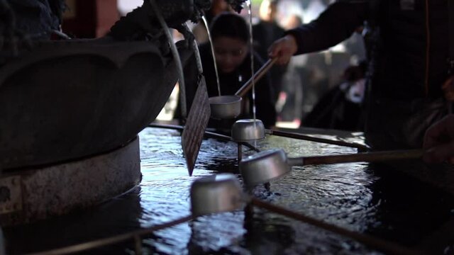 People drinking Holy water at Senso-ji japanese Temple asakusa district Tokyo japan.