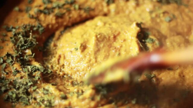 Home cooking preparation of Indian recipe called Shahi Paneer made with Cashew masala base and white cheese on pan being mixed with cubical paneer along with Kasuri or Kasoori methi herb