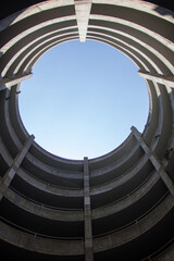 A low angle shot of a circular concrete parking garage structure