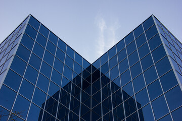 A low angle shot of a reflective city office building exterior