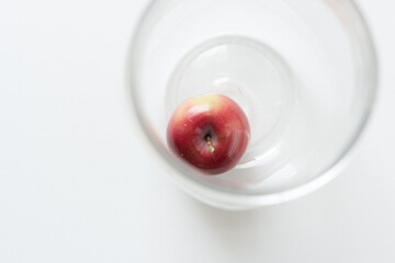 crab apple in a clear container on a white background