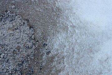 gray white texture of ash with sand and white snow outside