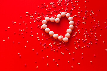 Heart shape in culinary candy on red background. Valentine 8 March Mother Women's Day or sales and black friday concept. Creative romantic love pattern. Copy space, flat lay, top view