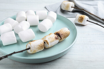 Fresh and roasted marshmallows on white wooden table