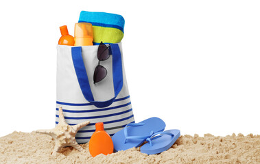 Stylish bag with beach accessories on sand against white background