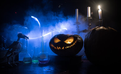 Halloween still-life background with different elements on dark toned foggy background. Selective...