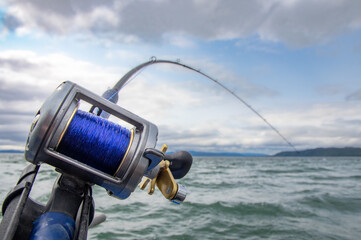 Rod and Reel on a boat Trolling (a form of fishing) for salmon in South East Alaska. - obrazy, fototapety, plakaty