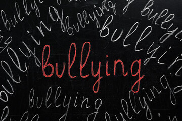 Many words Bullying written on blackboard, closeup view