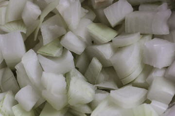 The texture of onions set aside in a large portion for cooking fritatas for many people.