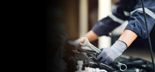 Mechanic works on the engine of the car in the garage. Repair service. Concept of car inspection service and car repair service.