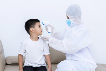 Doctor measuring temperature little child boy with infrared thermometer