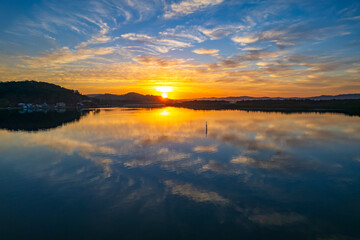 Sunrise waterscape with high cloud and reflections