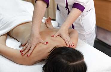 Obraz na płótnie Canvas Close up of woman masseur hands during back massage.