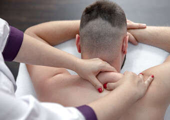 Fototapeta na wymiar Female hands do a back massage to a man in the salon.