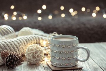 Close up of Christmas cup and winter decor details on blurred background.