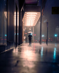 Lonely person walking in the city in the rain with an umbrella