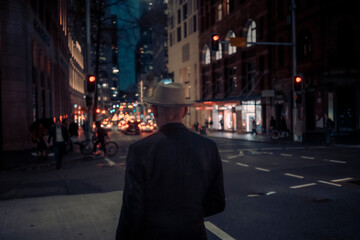 Fototapeta na wymiar Man on the street corner in a night city street scene