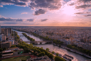 The sun sets over the Seine River as it flows lazily through the heart of Paris, France, as seen from the top of the Eiffel Tower.