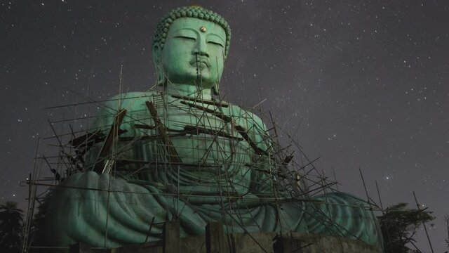 Time lapse 4K, Daibutsu or 'Giant Buddha' is a Japanese term often used informally for a large statue of Buddha, Giant Buddha with milky way moving in sky at night, Mae Tha Lampang Thailand.