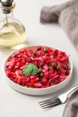Salad vinaigrette with beets and vegetables on a plate on the table. Healthy diet