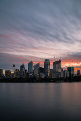 Sunset illuminating the wispy clouds in the sky above the Sydney city skyline