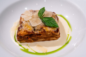 Closeup tasty traditional beef lasagne with cheese and basil leaves.