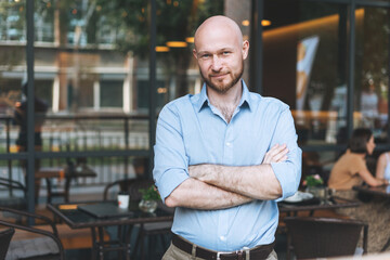 Portrait of Adult bald smiling attractive man forty years with beard in blue shirt businessman...