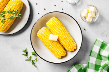 Cooked corn on the cob served with salt and butter. Light gray background. Top view - Powered by Adobe