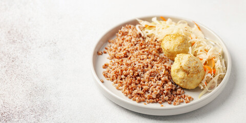 Fototapeta na wymiar Meatballs with buckwheat porridge and cabbage salad. Baby or diet nutrition