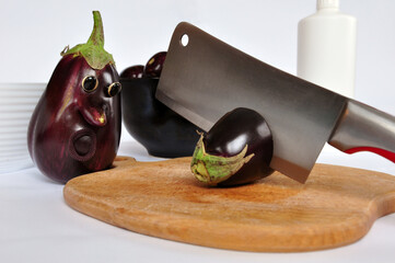 Concept food, horror of vegetables. Emotional scarred eggplant looking on  sliced vegetables by kitchen knife. Concept of fear. Stressed life.