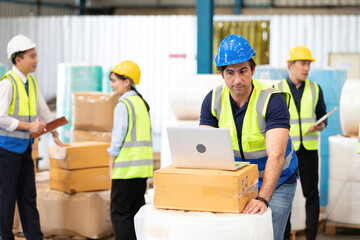 engineer or factory worker using laptop computer and thinking of something seriously in warehouse storage