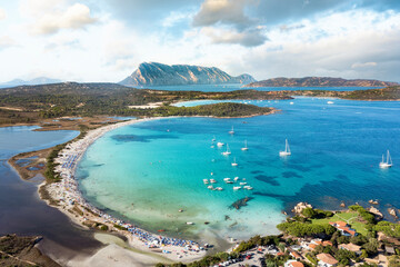 View from above, stunning aerial view of Lu Impostu beach with its beautiful white sand, and crystal clear turquoise water. Tavolara island in the distance, Sardinia, Italy.